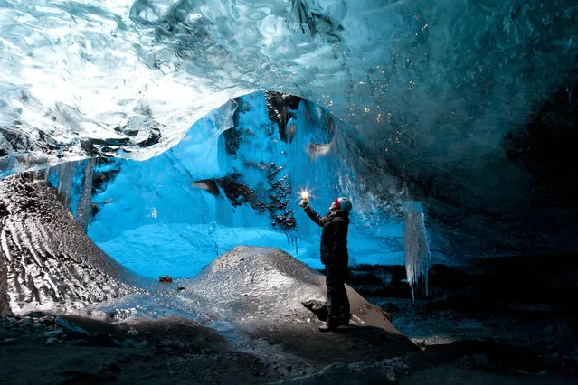 Rob Lott stands under the crystal ice cave in the Vatnajokull Glacier, Iceland. (Photo by Rob Lott/Barcroft Media)