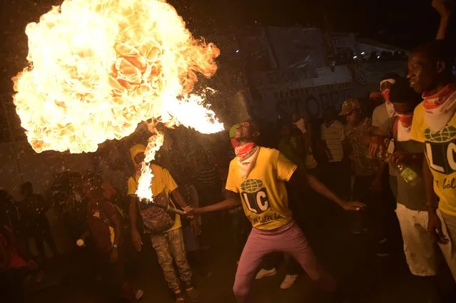 A fire- swallower performs during the third and final day of Carnival in the capital of Haiti, Port- au- Prince, on February 28, 2017. (Photo by Hector Retamal/AFP Photo)