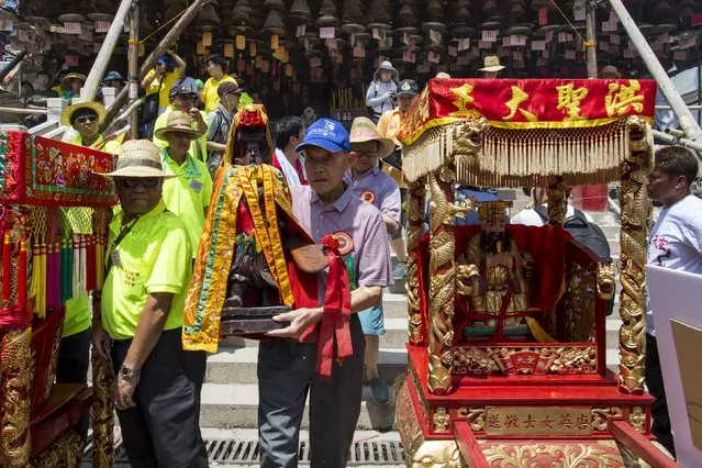 Participants carry a Chinese deity during a Bun Festival parade at Hong Kong's Cheung Chau island, China May 25, 2015. (Photo by Tyrone Siu/Reuters)