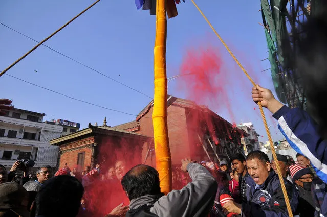 Members of Manandhar Guthi erecting ceremonial Bamboo Log known as “Chir” along with the vibrant cloth strips, which representing good luck charms, on the first day of Holi Celebration, the festivals of colors at Basantapur Durbar Square at Kathmandu on Sunday, March 05, 2017. People celebrate Holi in all over Nepal as well as in India. (Photo by Narayan Maharjan/NurPhoto via Getty Images)
