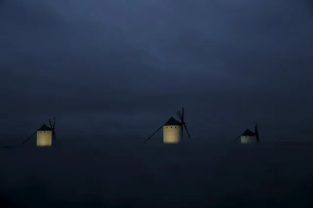 Windmills are seen at dusk in Campo de Criptana, Spain, April 4, 2016. Locals believe that Miguel de Cervantes drew inspiration from the windmills of Campo de Criptana to narrate the battle between Don Quixote and the windmills he mistook for giants. (Photo by Susana Vera/Reuters)