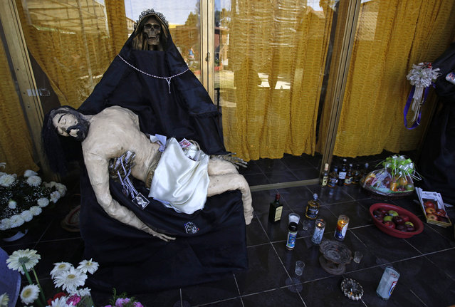 In this March 1, 2017 photo, a statue of Death Saint, or “Santa Muerte” holds a statue of Jesus on an alter inside a temple dedicated to the Santa Muerte, on the outskirts Mexico City in the state of Mexico. The Roman Catholic Church rejects the Death Saint but her following continues to grow. (Photo by Marco Ugarte/AP Photo)