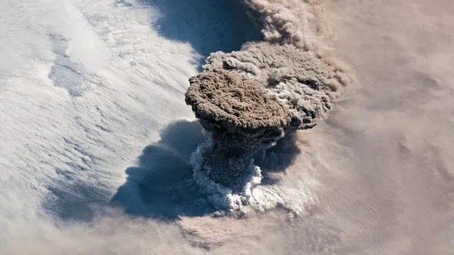 This handout image obtained courtesy of the NASA Earth Observatory taken on June 22, 2019, shows Raikoke volcano erupting in the Kuril Islands in Russia's Sakhalin Oblast region, near the Kamchatka Peninsula. Unlike some of its perpetually active neighbors on the Kamchatka Peninsula, Raikoke Volcano on the Kuril Islands rarely erupts. The small, oval-shaped island most recently exploded in 1924 and in 1778. The dormant period ended around 4:00 a.m. local time on June 22, 2019, when a vast plume of ash and volcanic gases shot up from its 700-meter-wide crater. (Photo by Joshua Stevens/NASA Earth Observatory/AFP Photo)