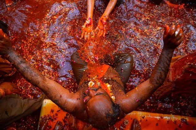 Indian revellers take part in the game of “Huranga” at The Dauji Temple in Mathura, some 100 kms south of New Delhi on March 14, 2017. “Huranga” is a game played between men and women a day after Holi, the festival of colours, during which men drench women with liquid colours and women tear off the clothes of the men. (Photo by Chandan Khanna/AFP Photo)