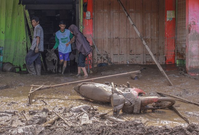 People clean up their flooded house following a flash flood in Tanah Datar, West Sumatra, Indonesia, 12 May 2024. At least 28 people were killed after heavy rain triggered flash floods and cold lava flow from Marapi volcano hitting villages in Tanah Datar and Agam Regency, West Sumatra province, according to the National Board for Disaster Management (BNPB). (Photo by Givo Alputra/EPA/EFE/Rex Features/Shutterstock)