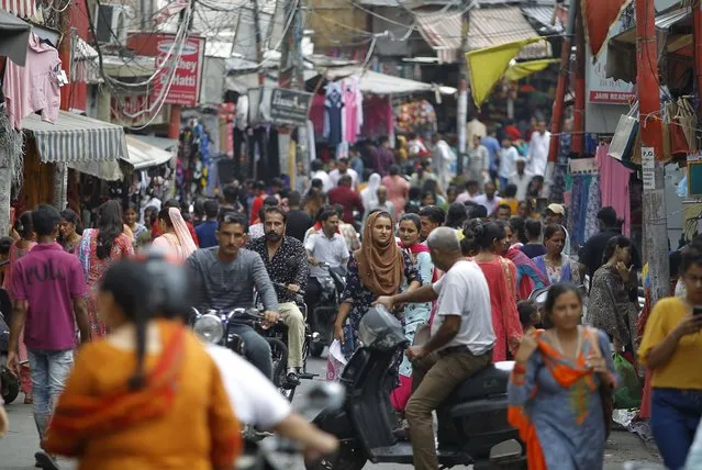 People throng a market on the eve of Eid al Adha, in Jammu, India, Sunday, August 11, 2019. Authorities in Indian-administered Kashmir said that they eased restrictions Sunday in most parts of Srinagar, the main city, ahead of an Islamic festival following India's decision to strip the region of its constitutional autonomy. There was no immediate independent confirmation of reports by authorities that people were visiting shopping areas for festival purchases as all communications and the internet remain cut off for a seventh day. (Photo by Channi Anand/AP Photo)