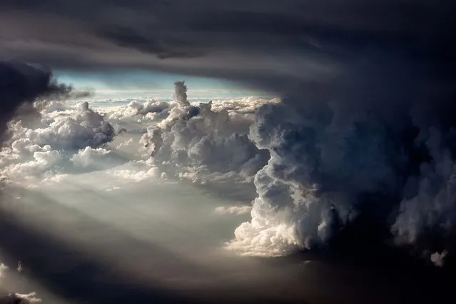 The sunset is seen behind the turbulent weather in Oklahoma as seen from an airplane in May 2011. (Photo by Mike Olbinski/Barcroft Media)
