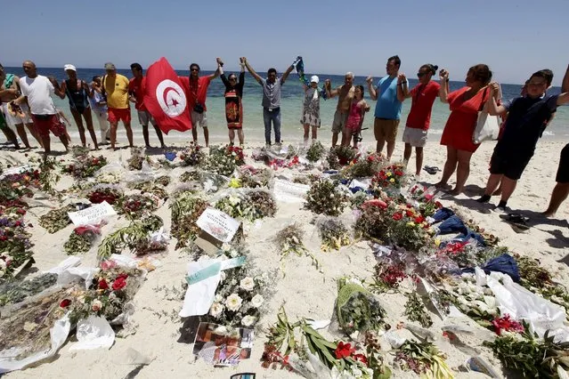 People join hands as they observe a minute's silence in memory of those killed in a recent attack by an Islamist gunman, at a beach in Sousse, Tunisia July 3, 2015. (Photo by Anis Mili/Reuters)