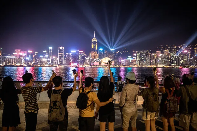 Protesters wave their phones and hold hands to form a human chain along Hong Kong's famous Avenue of Stars during an anti-government rally on August 23, 2019 in Hong Kong, China. Pro-democracy protesters have continued rallies on the streets of Hong Kong against a controversial extradition bill since 9 June as the city plunged into crisis after waves of demonstrations and several violent clashes. Hong Kong's Chief Executive Carrie Lam apologized for introducing the bill and declared it “dead”, however protesters have continued to draw large crowds with demands for Lam's resignation and completely withdraw the bill. (Photo by Chris McGrath/Getty Images)