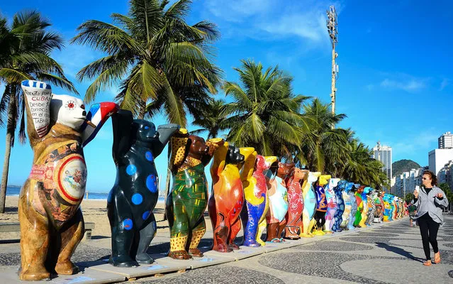 A woman walk along the exhibit “United Buddy Bears” at Leme beach in Rio de Janeiro, Brazil, Wednesday, April 30, 2014. Each bear statue represents a member state of the United Nations. Each was painted by an artist of the country represented. The “United Buddy Bears” stand together, hand in hand, symbolizing the future vision of a peaceful world. (Photo by Marcelo Fonseca/Estadão Conteúdo)