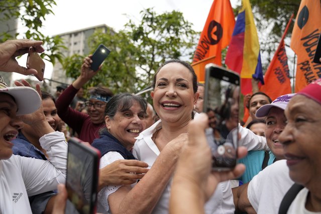 Opposition leader Maria Corina Machado ie embraced by supporters during a rally where she asked them to keep the faith, in San Antonio, Venezuela, Wednesday, April 17, 2024. The Biden administration on Wednesday reimposed oil sanctions on Venezuela, admonishing President Nicolás Maduro's attempts to consolidate his rule, actions that include blocking Machado, his main rival, from registering her candidacy or that of a designated alternative. (Photo by Ariana Cubillos/AP Photo)