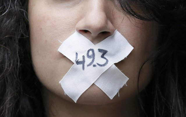 A woman with the numbers, “49-3” symbolically taped across her mouth attends a demonstration against French labour law reform in Paris, France, May 12, 2016. (Photo by Gonzalo Fuentes/Reuters)