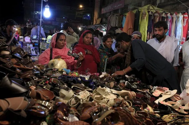 Women buy shoes at a stall ahead of Eid al-Fitr celebrations, which marks the end of Ramadan, in Rawalpindi, Pakistan, July 13, 2015. (Photo by Faisal Mahmood/Reuters)