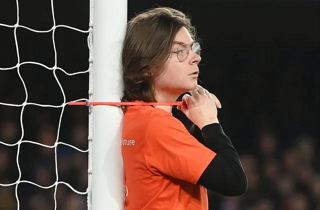 A protestor ties himself to the goalpost during the Premier League match between Everton and Newcastle United at Goodison Park on March 17, 2022 in Liverpool, England. (Photo by Chris Brunskill/Fantasista/Getty Images)