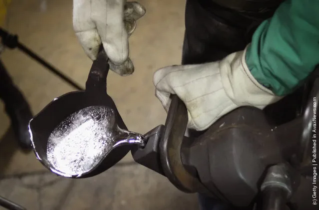 Martin Vega pours molten britannium into a mold to cast an Oscar statuette at R.S. Owens & Company during a media demonstration