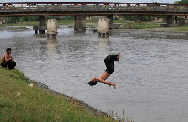 A man does a flip into the Sardaryab River on a hot day in Peshawar, Pakistan, May 2, 2016. (Photo by Fayaz Aziz/Reuters)