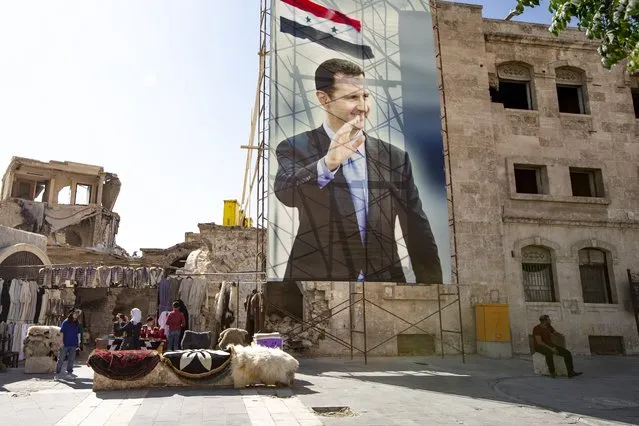 In this photo taken on Friday, Sept. 27, 2019, A huge portrait of Syrian President Bashar Assad is set in Old Market district, Aleppo, Syria. More than eight years of fighting has left many sections of Aleppo destroyed, and now authorities are pleading for international organisations to help fund restoration of the ancient city. (AP Photo/Alexander Zemlianichenko)