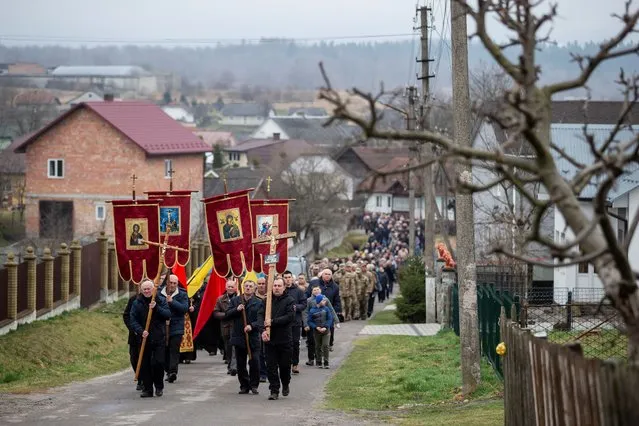 People attend the funeral of a Ukrainian soldier Vasyl Vekliuk, 59, who died in a shelling near Popasna in the Luhansk region, amid Russia's invasion of Ukraine, in Stebnyk, Lviv region, Ukraine, March 30, 2022. (Photo by Viacheslav Ratynskyi/Reuters)