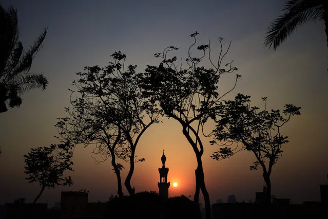 The sun sets over a minaret of a mosque during the Islamic holy month of Ramadan at Al-Azhar Park, one of the bustling city's few public parks in Cairo, Egypt, Saturday, July 4, 2015. (Photo by Hassan Ammar/AP Photo)