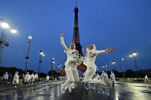 Members of the Egypte's delegation pose on the Iena Bridge during the opening ceremony of the Paris 2024 Olympic Games in Paris on July 26, 2024, as the Eiffel Tower is seen in the background. (Photo by Martin Bernetti/AFP Photo)