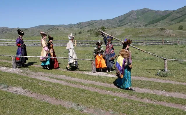 Models of the “Altyr” fashion theatre, dressed in Khakas national costumes, walk during a photo session, as a part of the rehearsal for the Tun-Pairam traditional holiday (The Holiday of the First Milk) celebration at a museum preserve outside Kazanovka village near Abakan in the Republic of Khakassia, Russia, May 28, 2016. (Photo by Ilya Naymushin/Reuters)