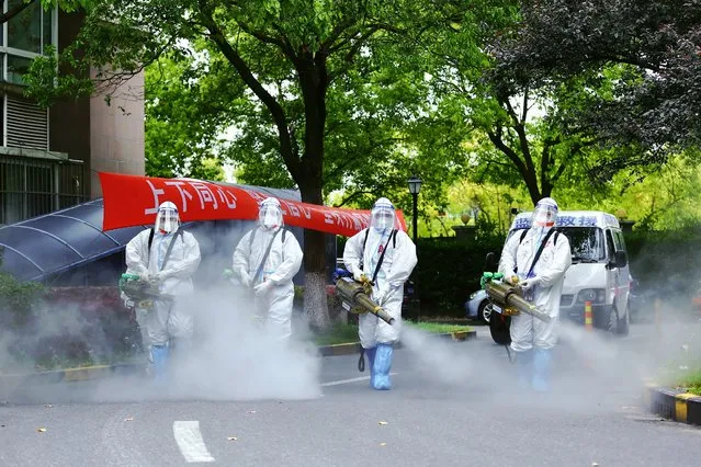 Members of the Blue Sky Rescue Team disinfect a residential community during the phased lockdown triggered by the COVID-19 outbreak on April 24, 2022 in Shanghai, China. (Photo by Chen Chen/VCG via Getty Images)