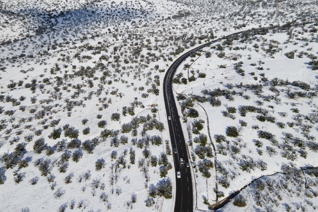 Cars drive along a snow-covered road in Santiago, Chile, Tuesday, August 6, 2024. (Photo by Matias Basualdo/AP Photo)