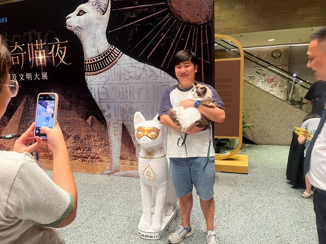 A cat visitor poses with its owner in the entrance hall of Shanghai Museum's “Meow Night”, in Shanghai, China, on August 31, 2024. (Photo by Casey Hall/Reuters)