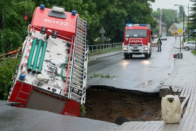 A fire department vehicle is half sunken in a road that collapsed after   heavy overnight rainstorms in Glucholazy, in lower Silesia, Poland, 29 May 2014. Storms caused severe flooding in the region. (Photo by Maciej Kulczynski/EPA)