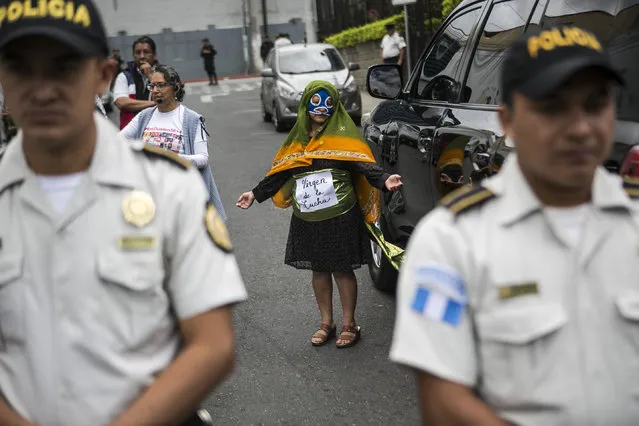 A demonstrator wearing a costume that reads in Spanish: “Virgin of the fight” protests outgoing President Jimmy Morales outside the Central American Parliament building where Morales will arrive to join the parliament as a lawmaker, in Guatemala City, Tuesday, January 14, 2020. Guatemala will inaugurate on Tuesday a new president as Morales exits amid swirling corruption accusations. (Photo by Oliver de Ros/AP Photo)