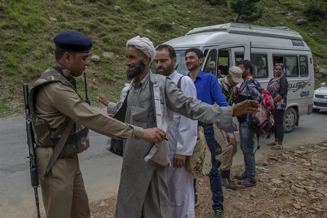 Indian paramilitary soldiers frisk a Kashmiri civilian as others wait for their turn at a temporary checkpoint near the pilgrim base camp in Pahalgam, about 100 Kilometers south of Srinagar, Indian controlled Kashmir, Tuesday, July 11, 2017. As India's government on Tuesday blamed separatist rebels for gunning down seven Hindu pilgrims and wounding more than a dozen in Kashmir before fleeing into the night, rebel groups in the disputed region condemned the rare, deadly attack on civilians and insisted they had no part in it. (Photo by Dar Yasin/AP Photo)