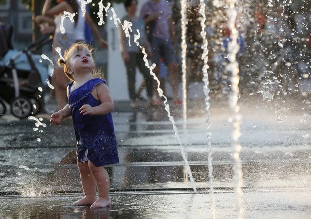 A girl plays in a water fountain during a hot summer day at Gorky park in Moscow, Russia, August 9, 2015. (Photo by Sergei Karpukhin/Reuters)