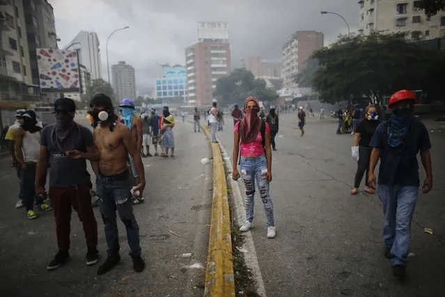 Anti-government demonstrators block a street during clashes with National Guards in Caracas, Venezuela, Thursday, July 20, 2017. Venezuelan President Nicolas Maduro and his opponents faced a crucial showdown Thursday as the country's opposition called for a 24-hour national strike. (Photo by Ariana Cubillos/AP Photo)