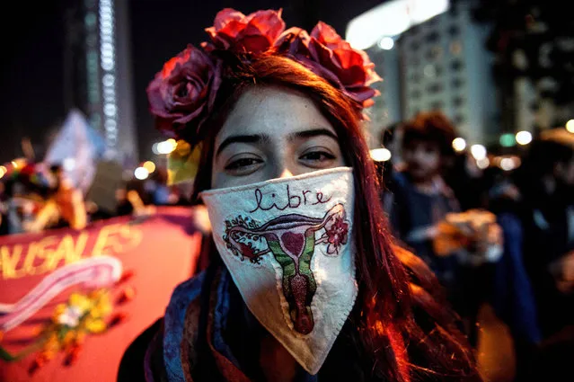 A woman wearing a handkerchief with an embroidered uterus and the Spanish word for “free”, takes part in a march in favor of a bill backed by President Michelle Bachelet, to legalize abortions in three situations: when the mother's life is in danger, when the fetus is not viable, and in cases of rape, in Santiago, Chile, Tuesday, July 25, 2017. (Photo by Martin Bernetti/AFP Photo)
