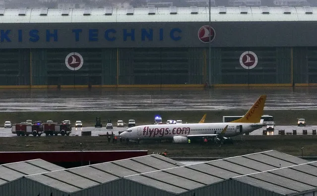 Members of emergency services work around a passenger plane that skidded off the runway at the Sabiha Gokcen Airport in Istanbul, Tuesday, January 7, 2020, temporarily shutting down the airport. The Boeing 737-800 from Sharjah, United Arab Emirates, operated by Turkish low-cost airline Pegasus, skidded as it landed in the morning and Istanbul governor's office said all 164 passengers were safely evacuated by emergency slides Storms and heavy rain have affected the city and transportation since Sunday night. (Photo by IHA via AP Photo)