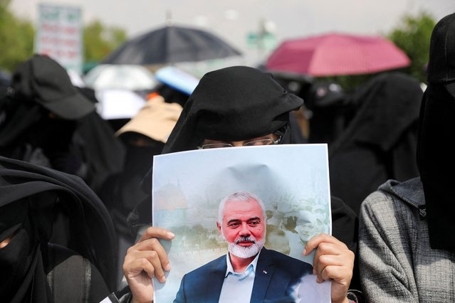 A student holds a poster of assassinated Hamas leader Ismail Haniyeh as she demonstrates with other students to show support to Palestinians in the Gaza Strip at the campus of Sanaa University in Sanaa, Yemen on August 14, 2024. (Photo by Khaled Abdullah/Reuters)