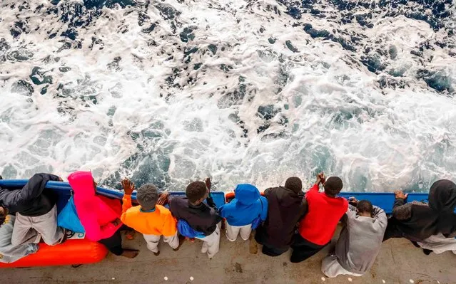 A group of migrants travel on board the Spanish NGO Maydayterraneo's Aita Mari rescue boat on February 10, 2020, one day after their rescue off the Libyan coast. 93 migrants (16 women, 40 men and 37 minors) from Mali, Ivory Coast and Cameroon yesterday were rescued by the Spanish NGO Maydayterraneo Search & Rescue in the central Mediterranean off the Libyan coast. (Photo by Pablo Garcia/AFP Photo)