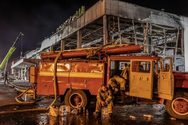 Firefighters rest after working all night following Russia’s deadly strike on the city’s shopping centre in Kremenchuk, Ukraine on June 28, 2022. The search for survivors continues. (Photo by Alessio Mamo/The Guardian)