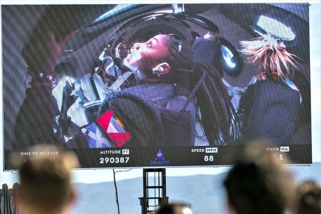 Guests watch a live broadcast from inside Virgin Galactic's rocket-powered plane Unity 22, showing space tourists Anastatia Mayers, 18, and her mother Keisha Schahaff, rear, at Spaceport America, near Truth or Consequences, N.M., Thursday, August 10, 2023. Virgin Galactic is taking its first space tourists on a long-delayed rocket ship ride. (Photo by Andrés Leighton/AP Photo)