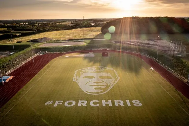 This aerial view taken on June 30, 2022, shows a gigantic portrait of past Danish rider Chris Anker Soerensen painted by a robot in the Holbaek Sportsvillage. Chris Anker Soerensen was a Danish professional road bicycle racer who took part in the Tour de France in 2012, and died in 2021 after being struck by a van driver while he was riding on his bike. (Photo by Mads Claus Rasmussen/Ritzau Scanpix via AFP Photo)