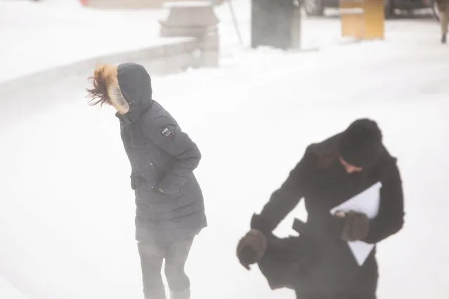 Women walk through blowing snow during blizzard in Buffalo, New York, U.S., February 27, 2020. (Photo by Lindsay DeDario/Reuters)