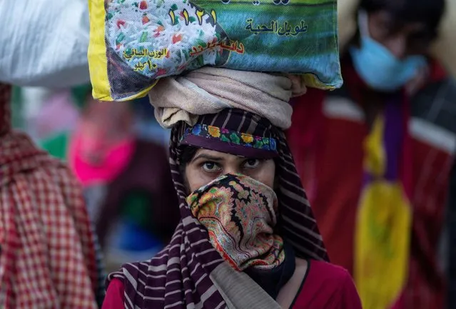 A migrant worker carries her belongings as she walks along a road to return to her village, during a 21-day nationwide lockdown to limit the spreading of coronavirus disease (COVID-19), in New Delhi, India, March 26, 2020. (Photo by Danish Siddiqui/Reuters)