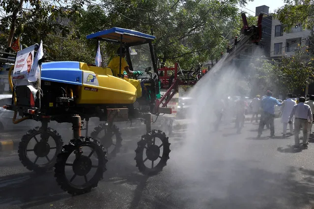 A municipal worker sprays disinfectant with a Japanese vehicle during a government-imposed nationwide lockdown as a preventive measure against the COVID-19 coronavirus in New Delhi, India on April 13, 2020. (Photo by Prakash Singh/AFP Photo)