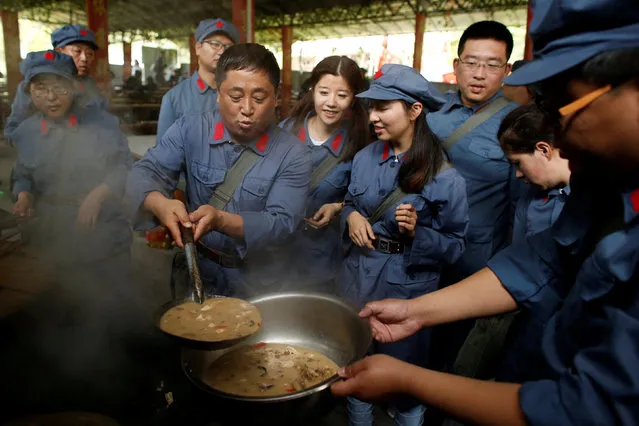 Participants dressed in replica red army uniforms distribute food during a Communist team-building course extolling the spirit of the Long March, organised by the Revolutionary Tradition College, in the mountains outside Jinggangshan, Jiangxi province, China, September 14, 2017. (Photo by Thomas Peter/Reuters)