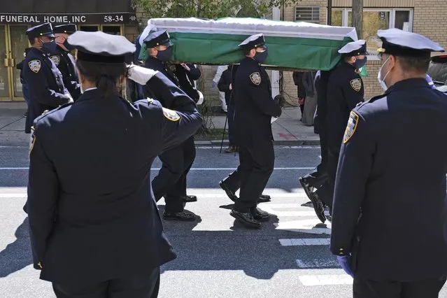 Members of the NYPD Honor Guard, wearing masks, carry the casket of Traffic Section Commander Mohammed Chowdhury during his funeral in New York, Wednesday, April 22, 2020. Chowdhury died on Sunday, April 19, 2020, from complications related to the new coronavirus. (Photo by Seth Wenig/AP Photo)
