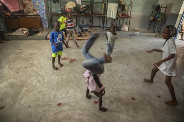 Children play in a school turned into a shelter after they were forced to leave their homes in Cite Soleil due to clashes between armed gangs, in Port-au-Prince, Haiti, Saturday, July 23, 2022. (Photo by Joseph Odelyn/AP Photo)