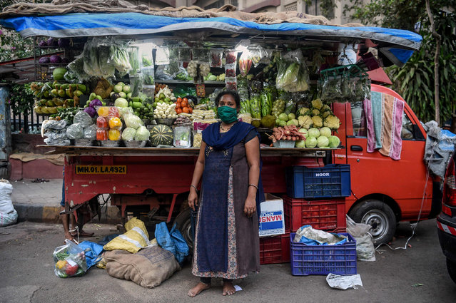 Lalita Kesharwani, 41, vegetable vendor, poses for a picture in front of her stall during a government-imposed nationwide lockdown as a preventive measure against the COVID-19 coronavirus, in Mumbai on April 22, 2020. Ahead of May Day on May 1, 2020, AFP portrayed 55 workers defying the novel coronavirus around the world. Lalita, who never shut her shop during lockdown said, We want to serve the people in these difficult times and that gives us satisfaction. She and her husband have been selling vegetables for 22 years and it is now part of their daily routine. With their work they feed their family and also the people who buy at their stall. (Photo by Punit Paranjpe/AFP Photo)