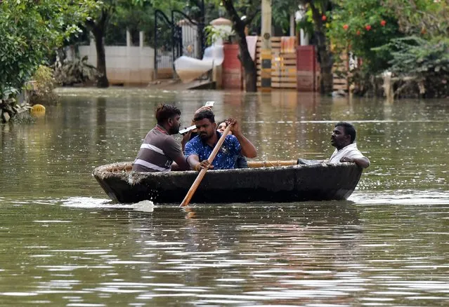 People use Coracle boat to move through a water-logged neighbourhood following torrential rains in Bengaluru, India on September 7, 2022. (Photo by Samuel Rajkumar/Reuters)
