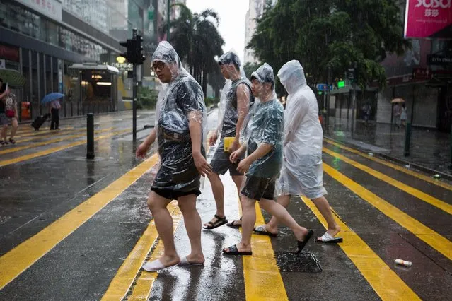 A group of tourists cross Nathan Road during typhoon Nida in Hong Kong, China, 02 August 2016. Nida is the first major typhoon to shut down Hong Kong this year. Classes at all schools are suspended for the day, ferries to and between outlying islands are also suspended as well as tram service on Hong Kong Island. (Photo by Jerome FavreEPA)