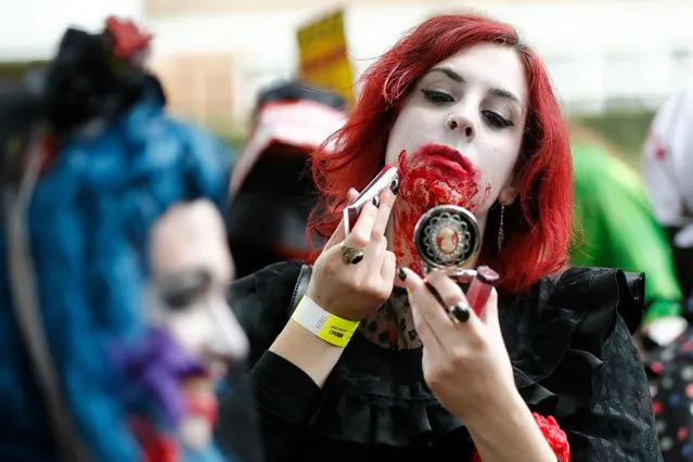 A participant checks theuir costume before taking part in a in a “Zombie Walk” on World Zombie Day, in London on October 7, 2017. (Photo by Tolga Akmen/AFP Photo)